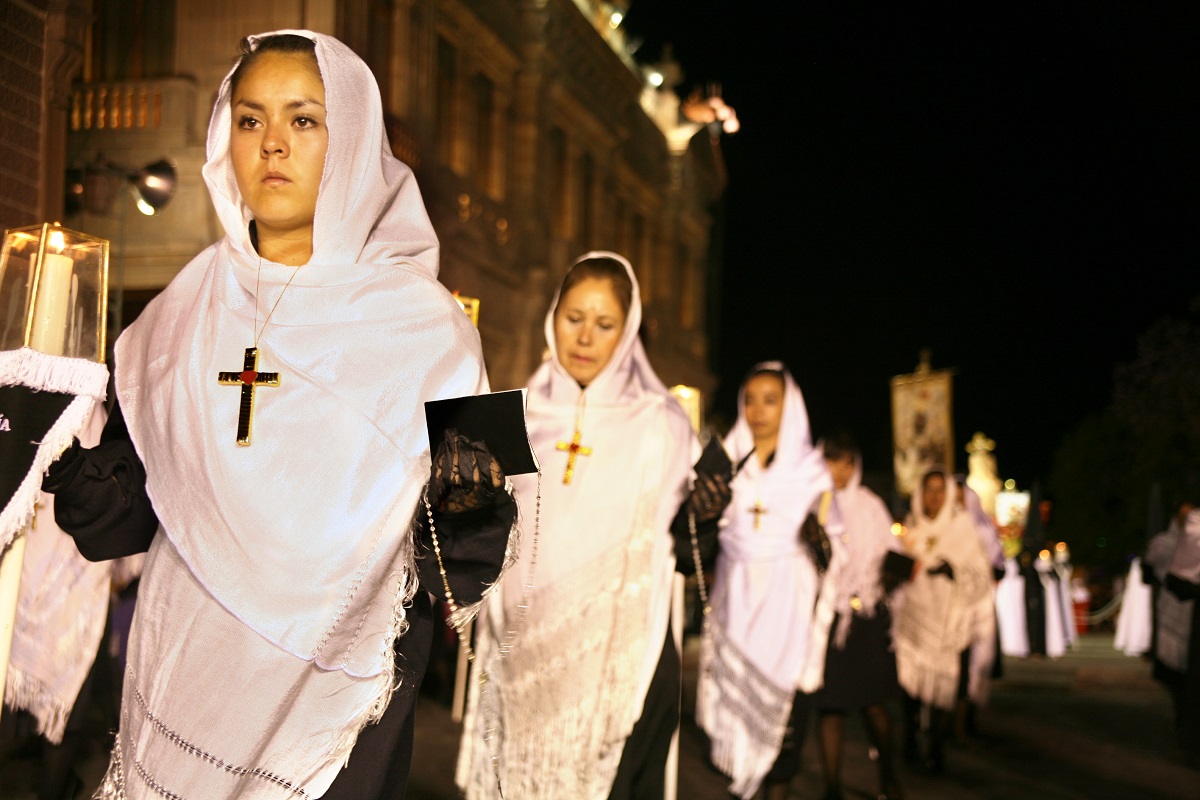 Mujeres caminan durante la Procesión del Silencio en San Luis Potosí como parte de las celebraciones de Semana Santa